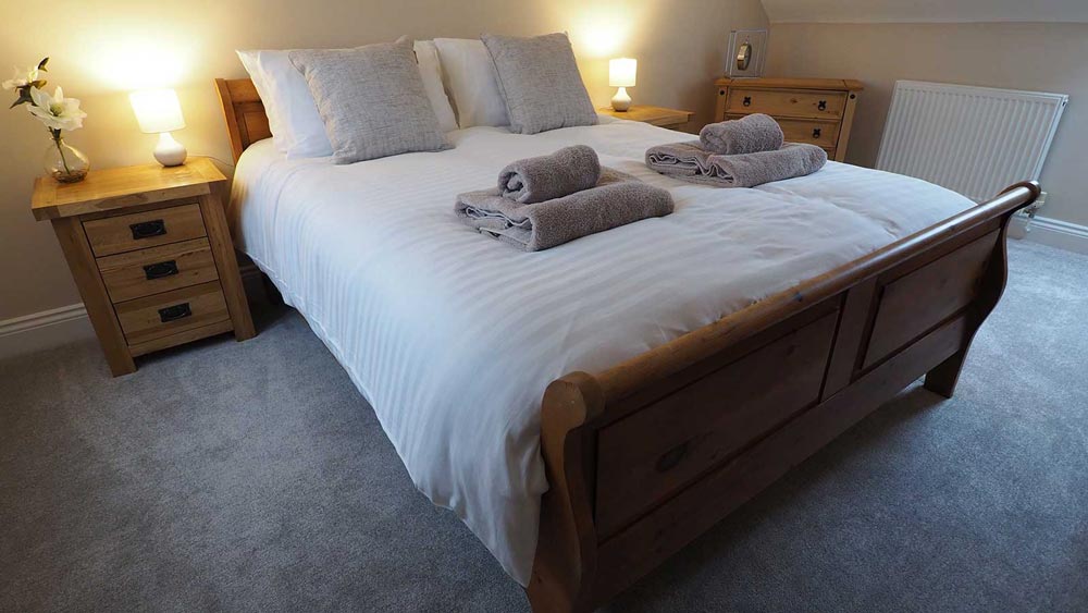 Freshly made king size bed in suffolk holiday barn
